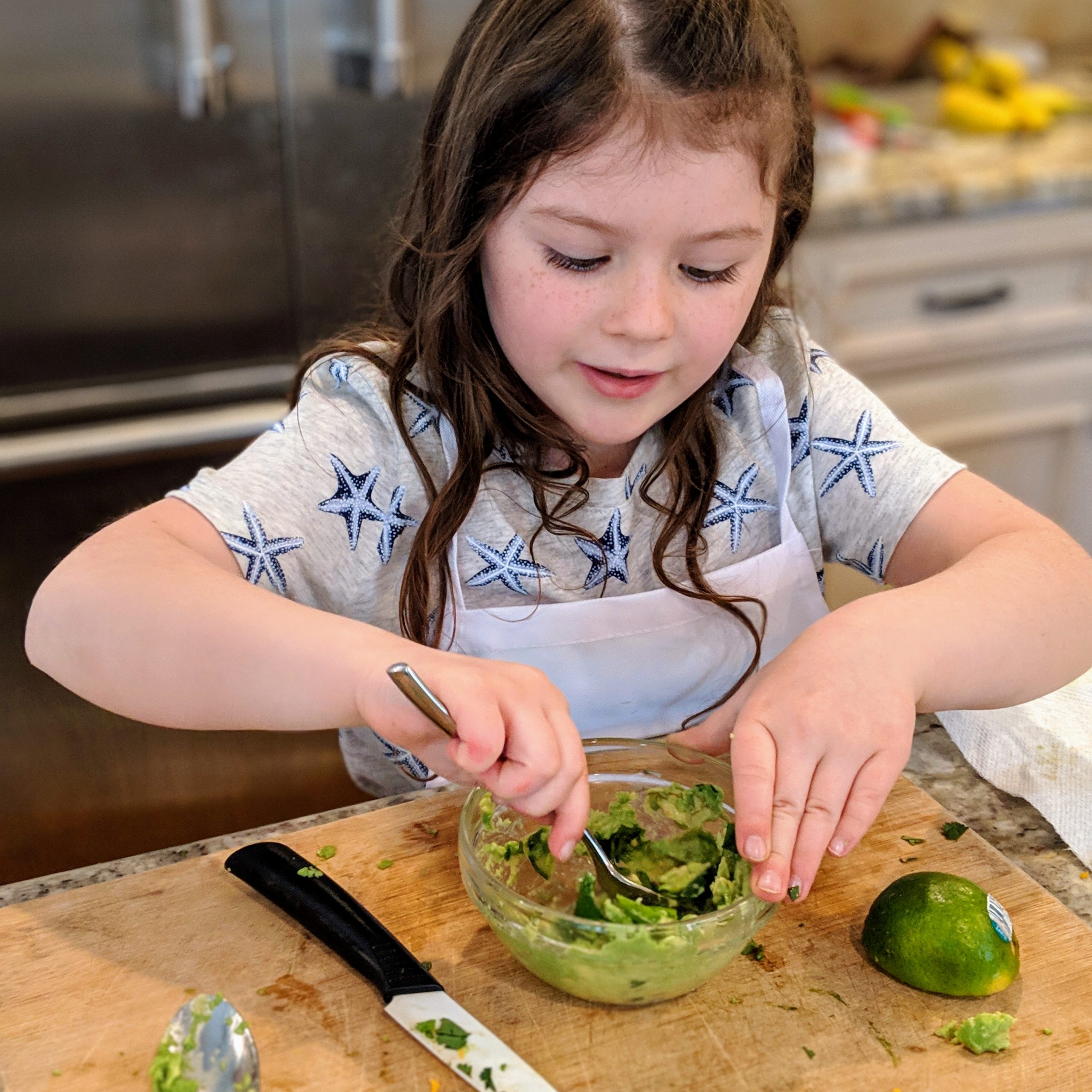child stirring guacamole